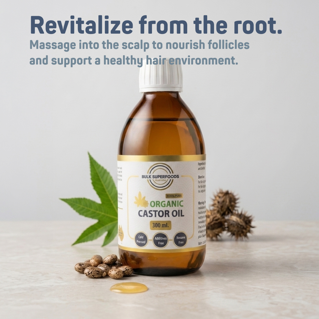 Bottle of organic castor oil with leaves and seeds on a light background